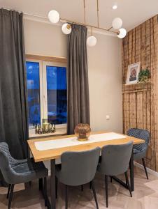 comedor con mesa de madera y sillas en Mere Apartments, en Pärnu