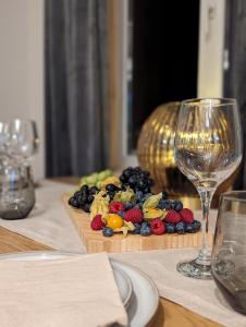 un plato de fruta en una mesa con una copa de vino en Mere Apartments, en Pärnu