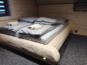 a large bed in a wooden room with two pillows at Trzy Kopce 