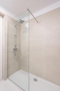 a shower with a glass door in a bathroom at Cozy Business Area 1BR near Aviatiei in Bucharest