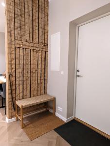 una puerta que conduce a una habitación con un banco al lado en Mere Apartments, en Pärnu
