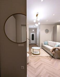 a living room with a couch and a mirror at Mere Apartment - Private Yard, Sauna and Pet Friendly in Pärnu