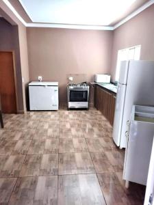 an empty kitchen with refrigerator and appliances in it at Area de lazer Santa Fé in Jardinópolis