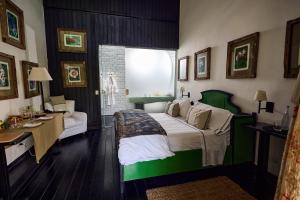 Un dormitorio con una cama verde y blanca y un escritorio en Hotel Garzón, en Garzón