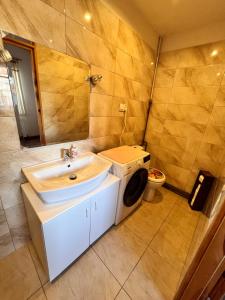 a bathroom with a sink and a washing machine at Apartament u Doroty in Sanok