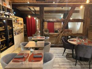 un restaurant avec des tables et des chaises en bois ainsi qu'un bar dans l'établissement Hotel Colmar Vignes Eguisheim, à Eguisheim