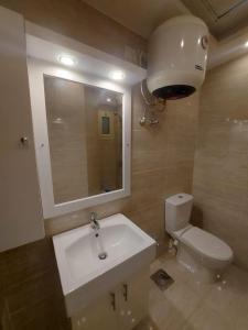 Sharm Hills Resort في شرم الشيخ: حمام مع حوض ومرحاض ومرآة