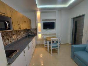 Sharm Hills Resort في شرم الشيخ: مطبخ مع طاولة وأريكة زرقاء
