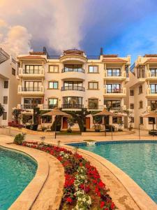 Sharm Hills Resort في شرم الشيخ: فندق فيه مسبح ومبنى