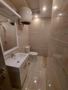 Sharm Hills Resort في شرم الشيخ: حمام مع حوض أبيض ومرحاض