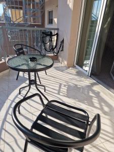 a glass table and chairs on a balcony at Zorzet in Karditsa