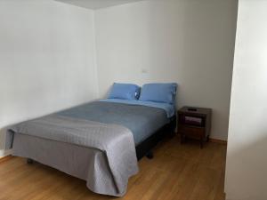 Un dormitorio con una cama con almohadas azules y una mesa. en Casa Macfarland Boutique en Ensenada