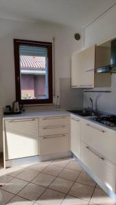 een keuken met witte kasten en een raam bij La casa del Sole a Cesena in Cesena