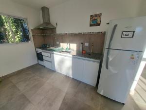 a kitchen with a white refrigerator and a sink at Complejo Pino Azul in General Roca