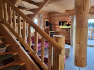 a staircase in a log cabin with a bedroom at Böhmerwald Lodges in Ulrichsberg