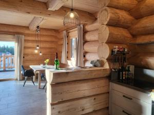a kitchen in a log cabin with a counter and a table at Böhmerwald Lodges in Ulrichsberg