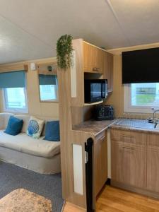 a small kitchen with a couch in a caravan at Newquay Bay Porth Caravan - 8 Berth in Newquay