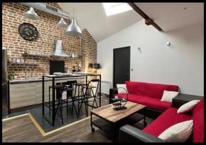 een woonkamer met een rode bank en een keuken bij 06. Le New york Style By Fanny .S in Saint-Quentin