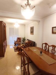 une salle à manger avec une table, des chaises et un lustre dans l'établissement Apartamento Sants de la Piedra, à Sagonte
