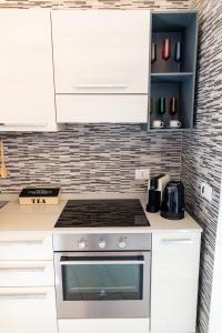 a kitchen with white cabinets and a stove top oven at Loft 12/A in Modugno +20 photos