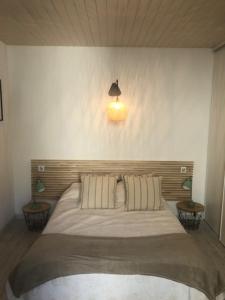 ein Schlafzimmer mit einem großen Bett mit einer Lampe an der Wand in der Unterkunft Villa Maurice avec piscine centre La Rochelle in La Rochelle
