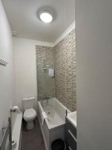 a bathroom with a toilet and a tub and a sink at Stylish Ground Floor Apartment Nr Gloucester Docks, by Sauvignon Stays 