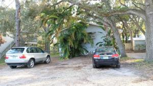 two cars parked in front of a house at Lenny's Cooperative Hostel in Clearwater