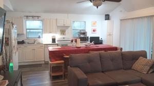 a living room with a couch and a table in a kitchen at Lenny's Cooperative Hostel in Clearwater