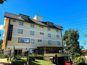 un gran edificio blanco con techo negro en Hotel Golden Hills en Canela