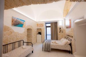1 dormitorio con 2 camas y pared de piedra en maison27, en Bari
