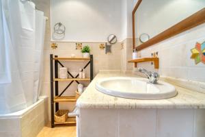 a bathroom with a sink and a mirror and a tub at Dúplex en centro, San Ildefonso in Jaén +12 photos