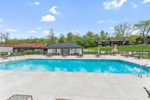 a swimming pool with tables and chairs around it at Modern Lake Geneva Condo with Year-Round Views in Lake Geneva