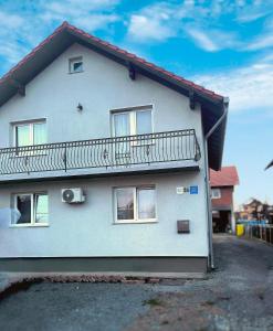 uma casa branca com uma varanda ao lado em APARTMAN PETAR em Slavonski Brod