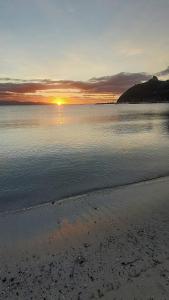 - un coucher de soleil sur une étendue d'eau avec une plage dans l'établissement Trilocale Margine Rosso, à Quartu SantʼElena