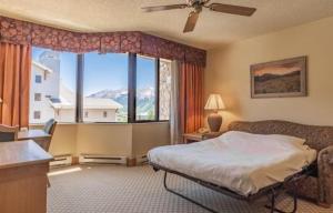 a bedroom with a bed and a large window at Studio 565 Perfect Location with Pool and Hot Tub in Crested Butte