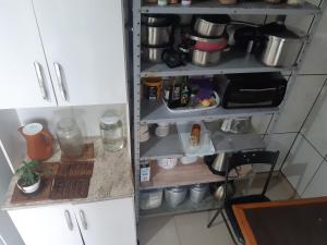uma prateleira de cozinha numa cozinha com alimentos em Bairro tranquilo ha dez minutos de carro do centro da cidade em Curitiba