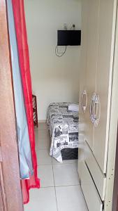 een kleine slaapkamer met een bed en een rood gordijn bij A sossego in Cayru