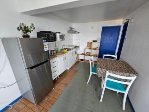 een kleine keuken met een tafel en een koelkast bij Santorini in Quintero