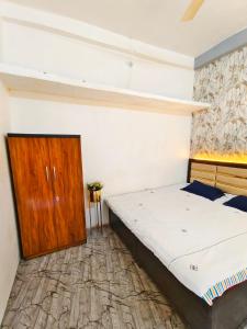 a bedroom with a bed and a wooden cabinet at Shivay homestay ujjain in Ujjain
