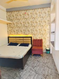 - une chambre avec un lit et une chaise dans l'établissement Shivay homestay ujjain, à Ujjain