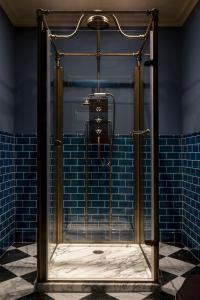 a shower in a bathroom with blue tiles at Kildrummy Inn in Kildrummy