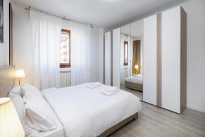アッサーゴにあるアパートメント フォーラムの白いベッドルーム(ベッド1台、鏡付)