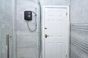 a shower with a white door in a bathroom at Myrtle House - By Sigma Stays in Crewe