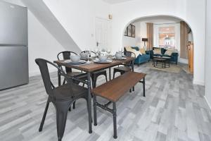 a dining table and chairs in a living room at Myrtle House - By Sigma Stays in Crewe