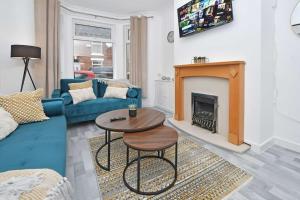 a living room with a blue couch and a fireplace at Myrtle House - By Sigma Stays in Crewe