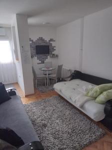 ein Wohnzimmer mit einem Bett, einem Sofa und einem Tisch in der Unterkunft Jugi in Novi Pazar