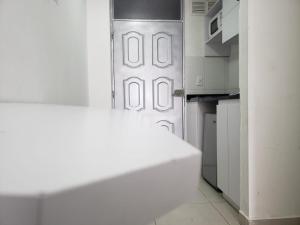uma porta branca num quarto com uma cozinha em Apartahotel Barú - Usaquén em Bogotá
