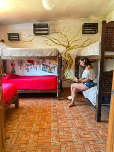 una donna seduta su un letto a castello in una stanza di Historika Hostel Cultural a San Cristóbal de Las Casas
