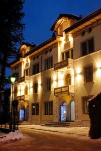 a large white building with lights on it at night at Residence Hotel Serenella in Aprica