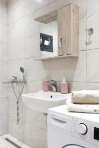 W białej łazience znajduje się umywalka i lustro. w obiekcie Nikolas Villa w mieście Gournes